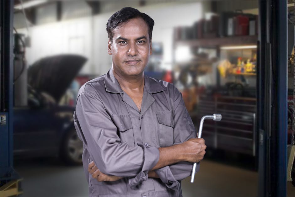 Friendly auto mechanic smiling inside a bright service center